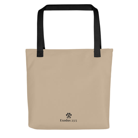 Beige tote bag with black handles and 'Exodus 23:5' text on a white background