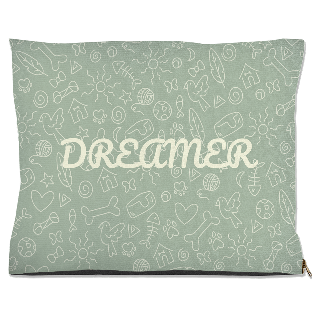 A sage green pet bed with the word, " Dreamer", on the front with a design of pet bones and toys.