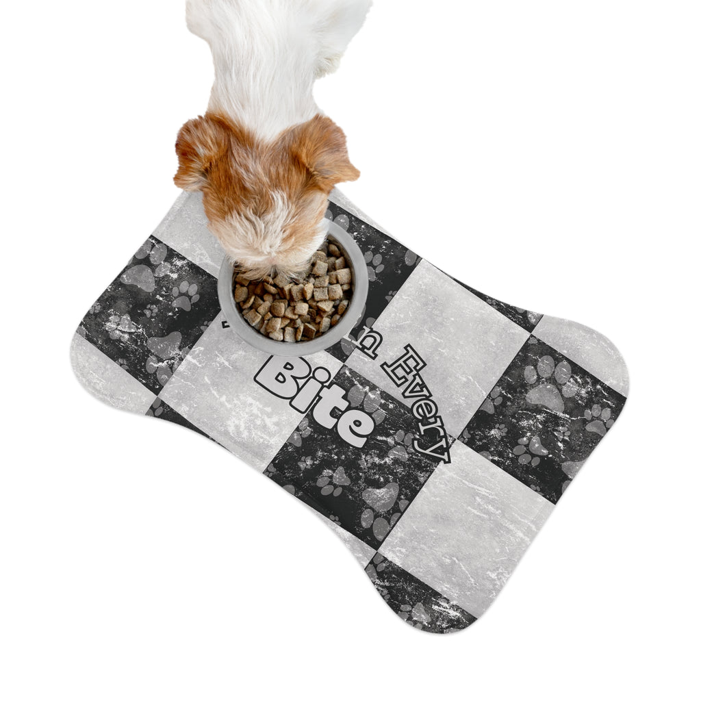 Bone‑shaped plush pet feeding mat in black and white checkerboard paw print design, featuring the phrase “Faith in Every Bite”.