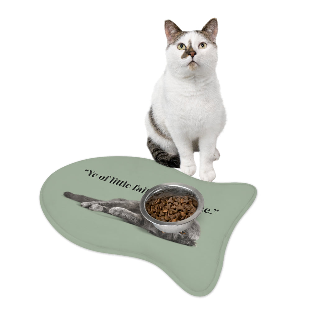 Fish‑shaped plush pet feeding mat in sage green with grey cat image and text “Ye of little faith… refill me.” across the center.