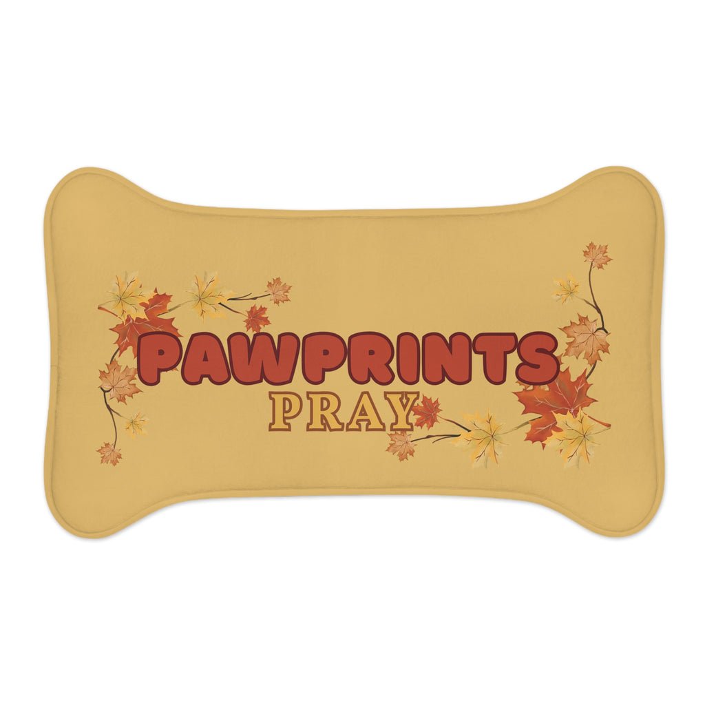 Bone-shaped golden yellow pet feeding mat with fall leaves and “Pawprints Pray” message in the cente
