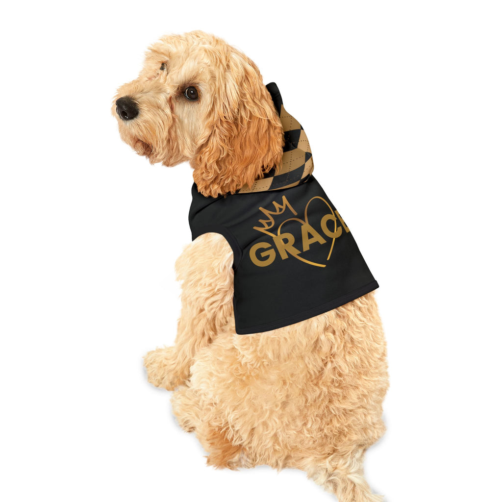 Light-colored dog wearing black GRACE pet hoodie with gold crown and heart design, plaid hood detail.