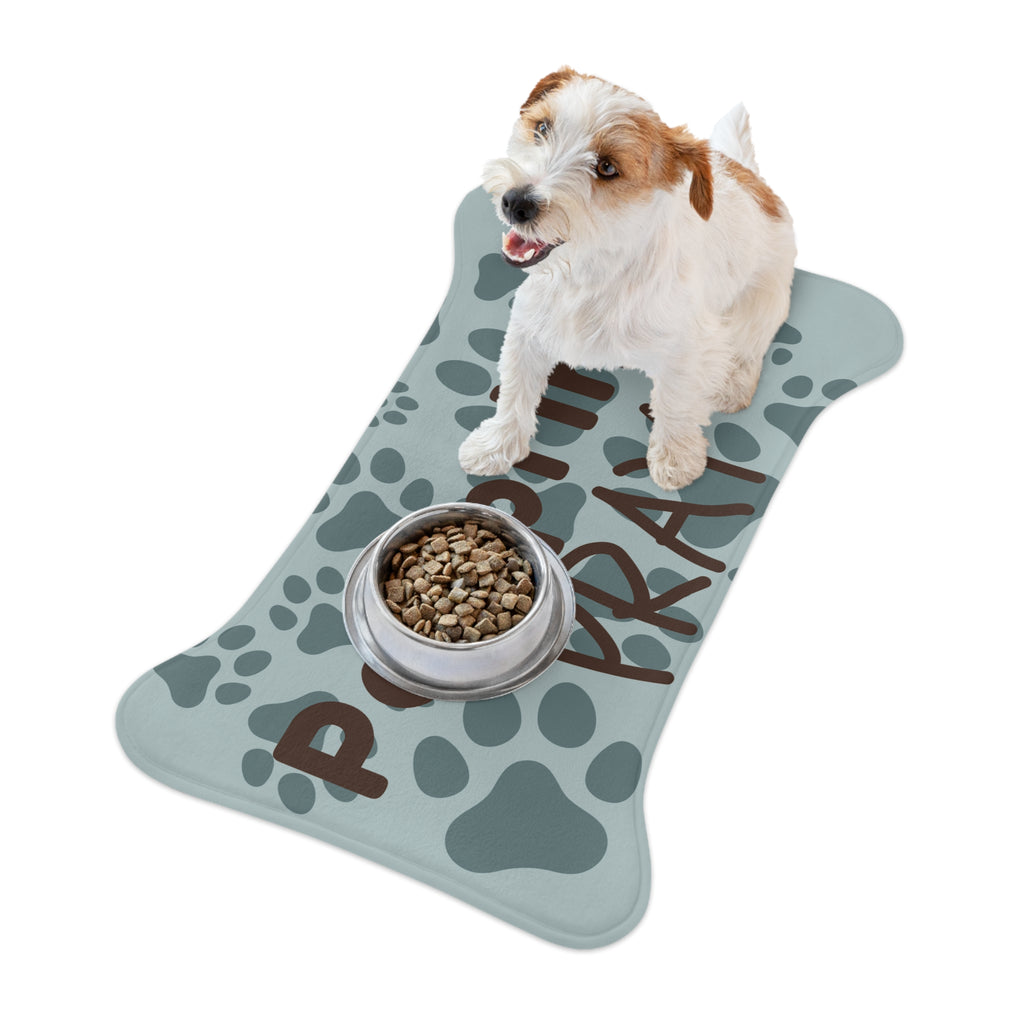 Bone‑shaped plush pet feeding mat with aqua background, dark grey paw print pattern, and brown text “Pawprints Pray”.