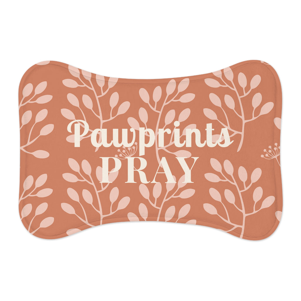 Flat view of bone-shaped pet feeding mat with terracotta background and light floral pattern.