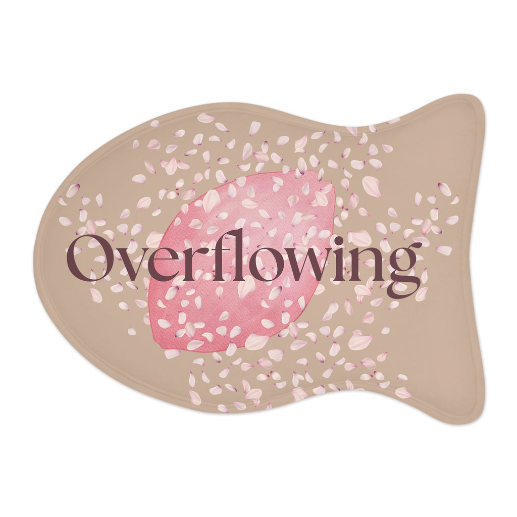 Beige pet feeding mat with pink petal design and the word “Overflowing” printed across the center – symbolizing faith, love, and abundance at mealtime.