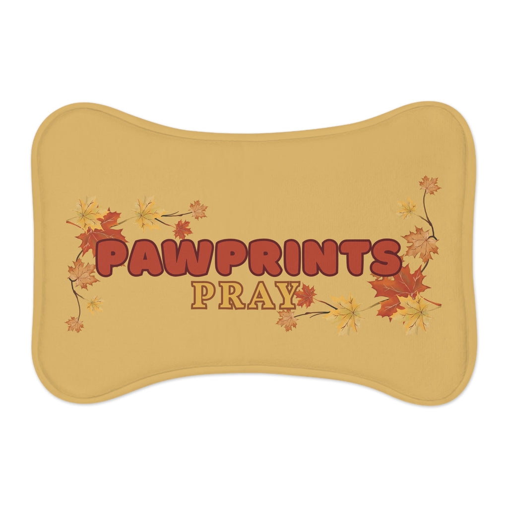 Bone-shaped golden yellow pet feeding mat with fall leaves and “Pawprints Pray” message in the cente