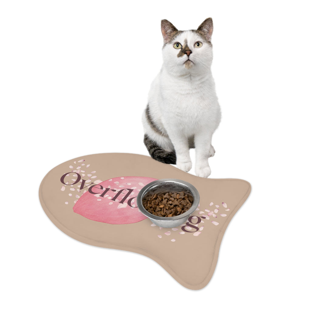 White and gray cat sitting beside rose petal designed fish-shaped “Overflowing” pet feeding mat
