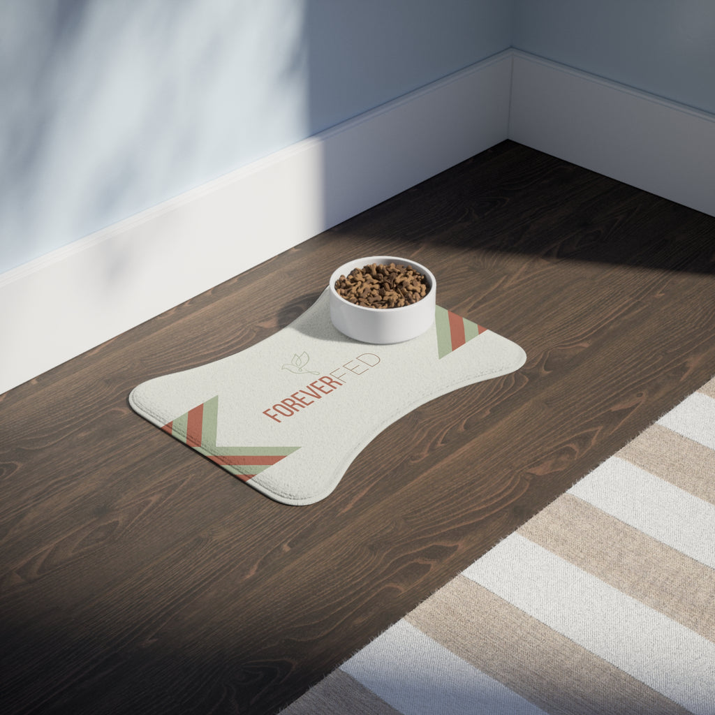 Bone-shaped plush pet feeding mat with cream background, geometric side patterns in muted sage and rust, and “Forever Fed” text with minimalist dove graphic in the center.