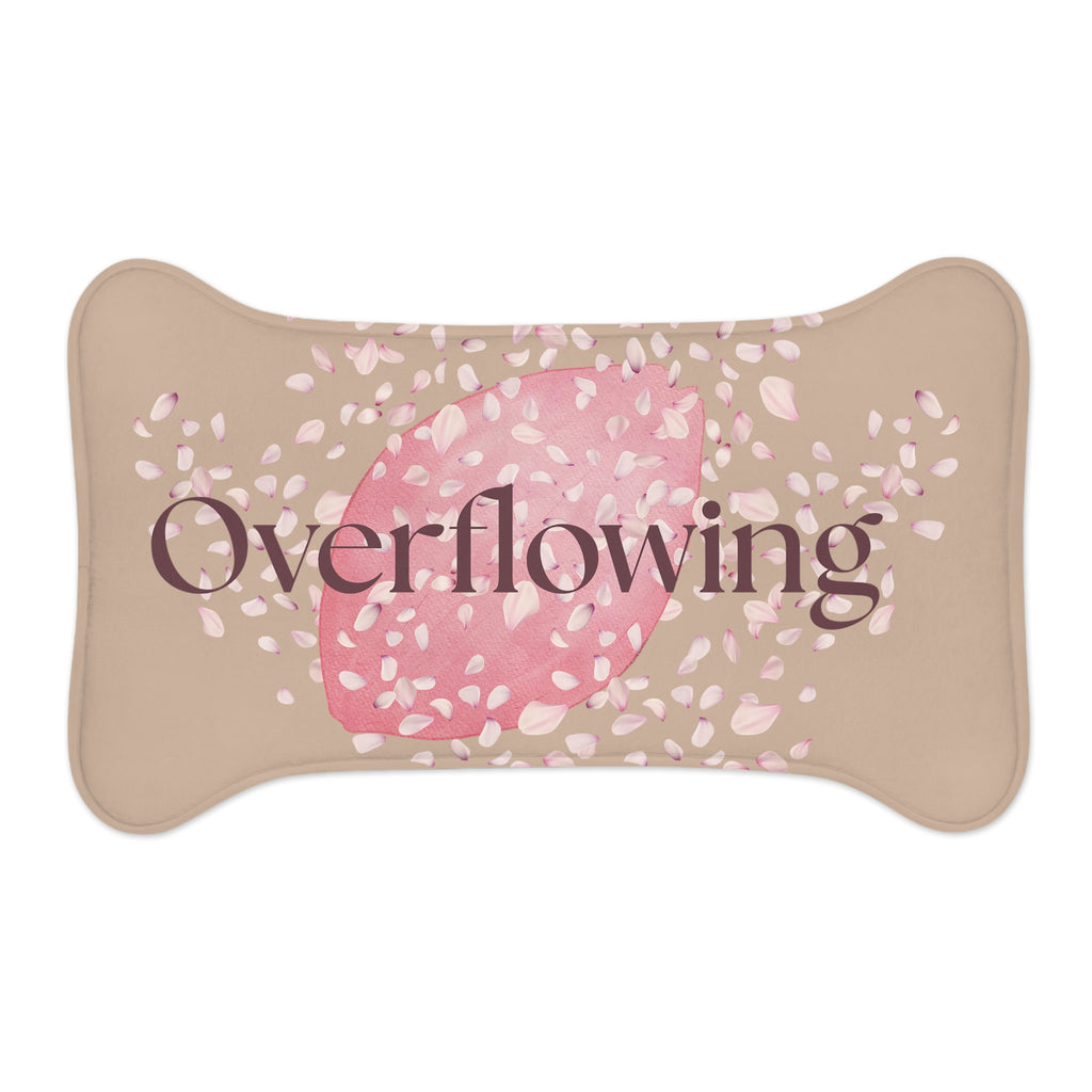 Beige pet feeding mat with pink petal design and the word “Overflowing” printed across the center – symbolizing faith, love, and abundance at mealtime.