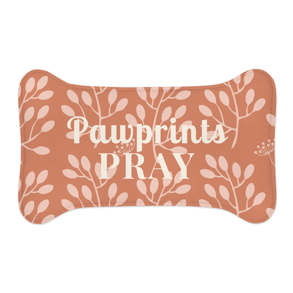 Flat view of bone-shaped pet feeding mat with terracotta background and light floral pattern.