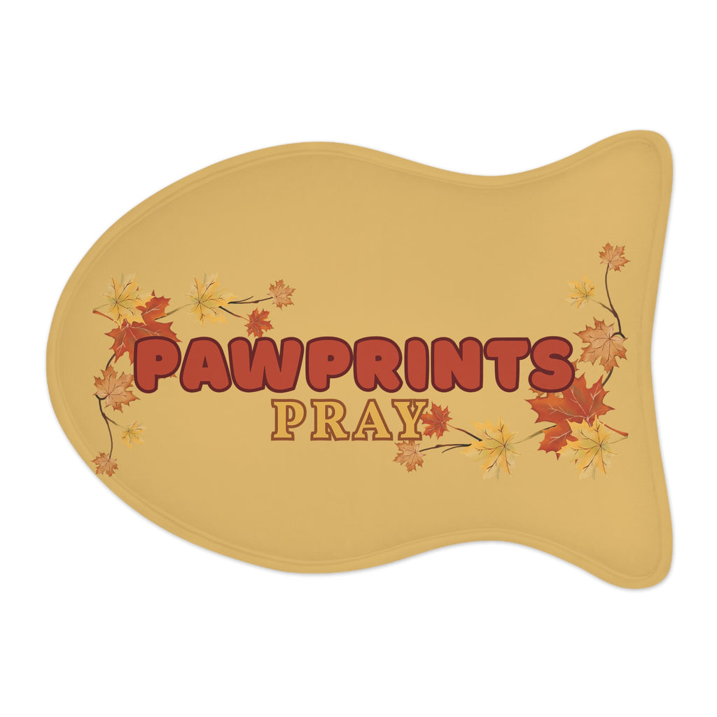 Fish-shaped golden yellow pet feeding mat with fall leaves and “Pawprints Pray” message in the cente