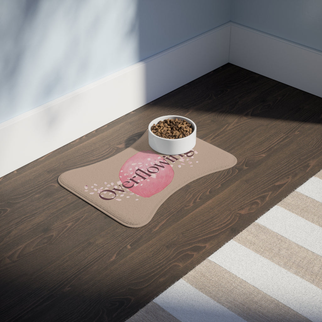 Rose petal designed “Overflowing” pet feeding mat with bowl of kibble in a sunlit kitchen corner