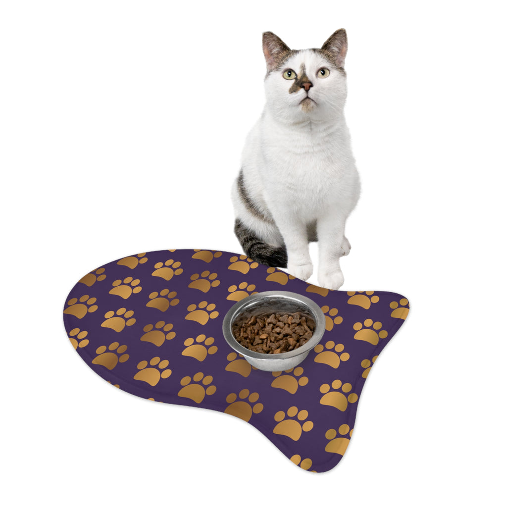 Fish‑shaped plush pet feeding mat in dark purple with gold heart‑of‑paw‑prints graphic 