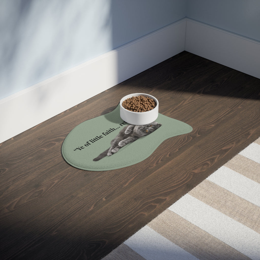 Fish‑shaped plush pet feeding mat in sage green with grey cat image and text “Ye of little faith… refill me.” across the center.