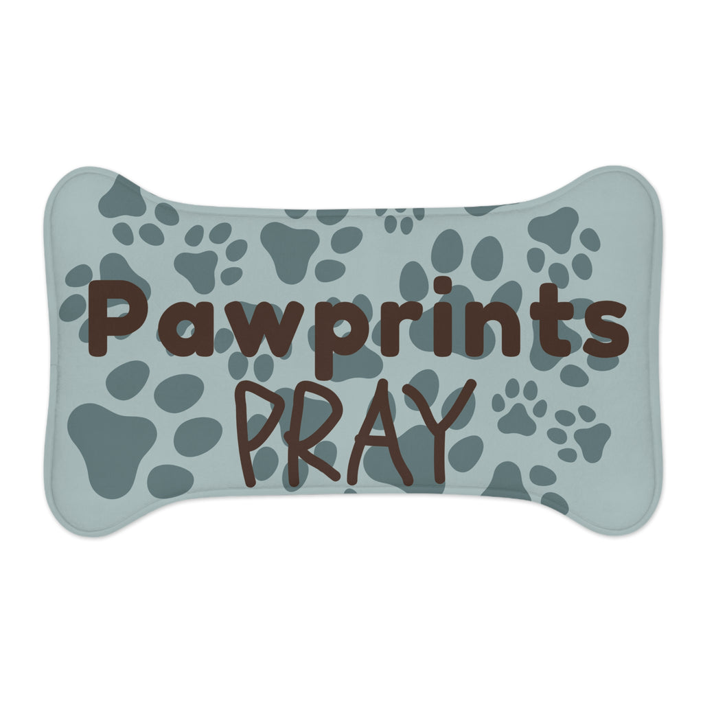 Bone‑shaped plush pet feeding mat with aqua background, dark grey paw print pattern, and brown text “Pawprints Pray”.