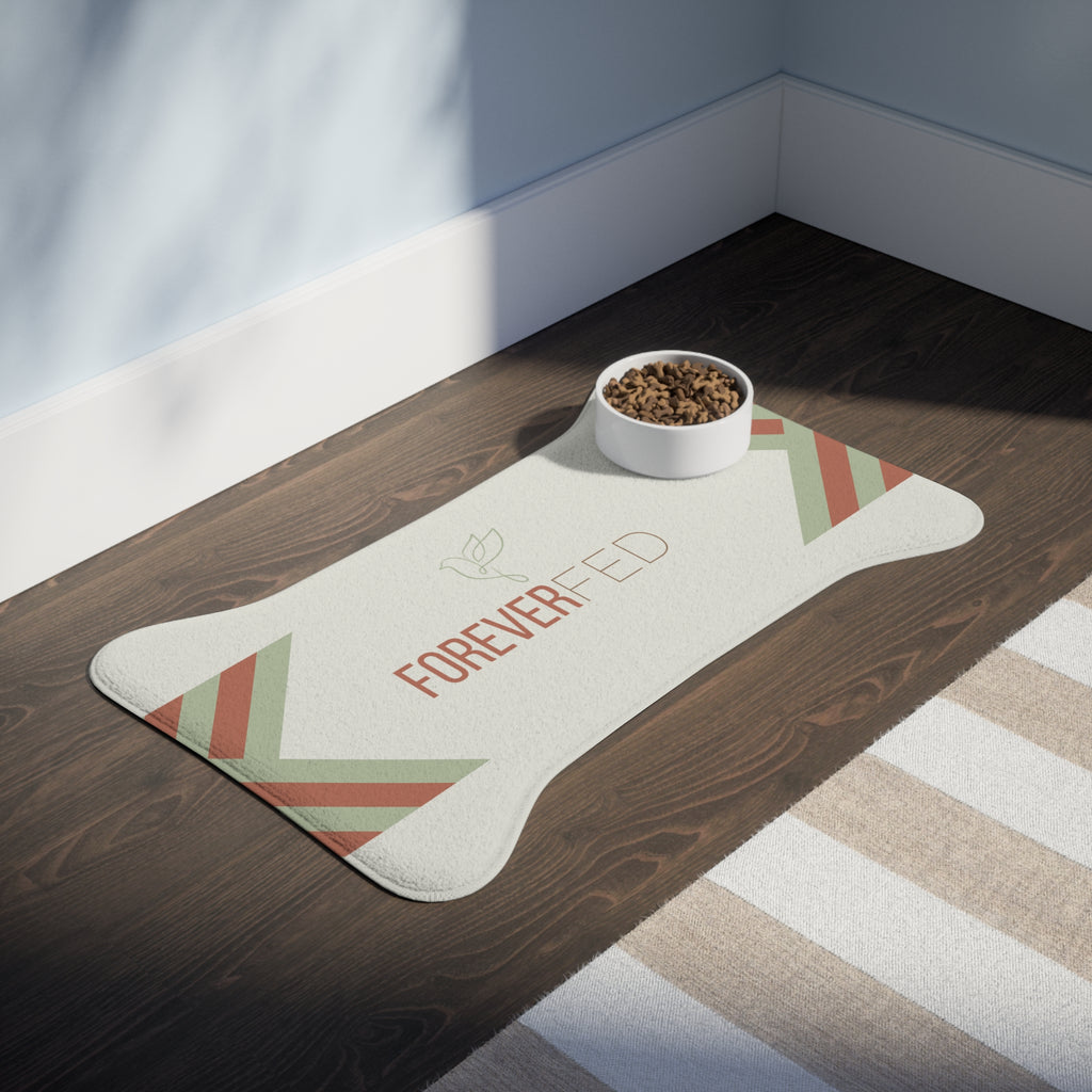Bone-shaped plush pet feeding mat with cream background, geometric side patterns in muted sage and rust, and “Forever Fed” text with minimalist dove graphic in the center.