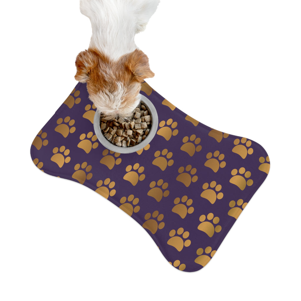 Bone‑shaped plush pet feeding mat in dark purple with gold heart‑of‑paw‑prints graphic 
