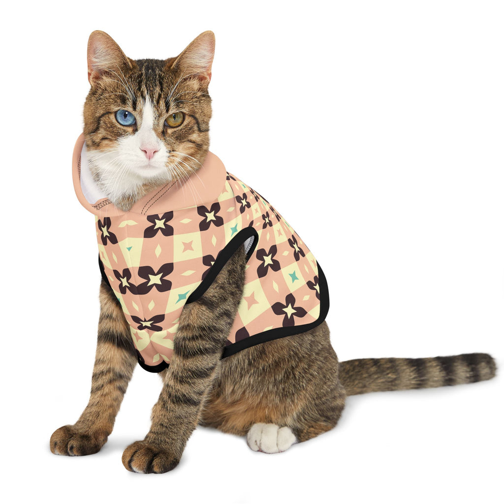 Front facing brown cat with one blue eye and one brown eye wearing the light peach geometric hoodie. 