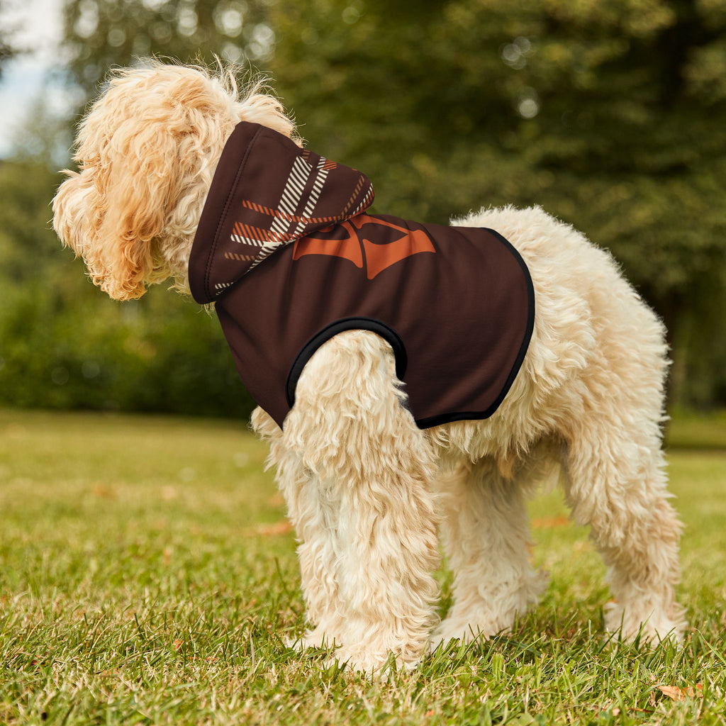 Light-colored dog standing outdoors in brown plaid hooded hoodie with orange “LOVE” paw print graphic.