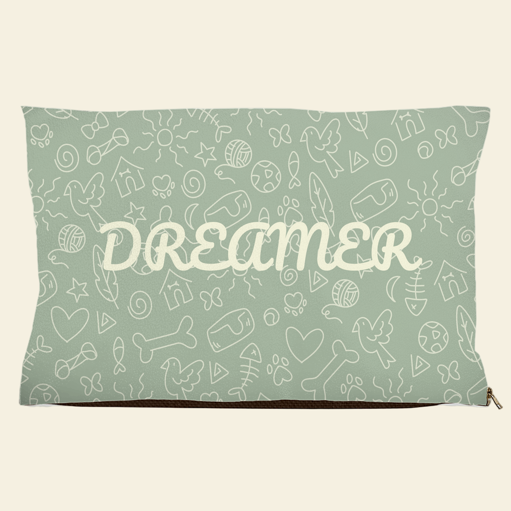 Sage green pet bed with Dreamer text and doodle design of bones, hearts, fish, and birds
