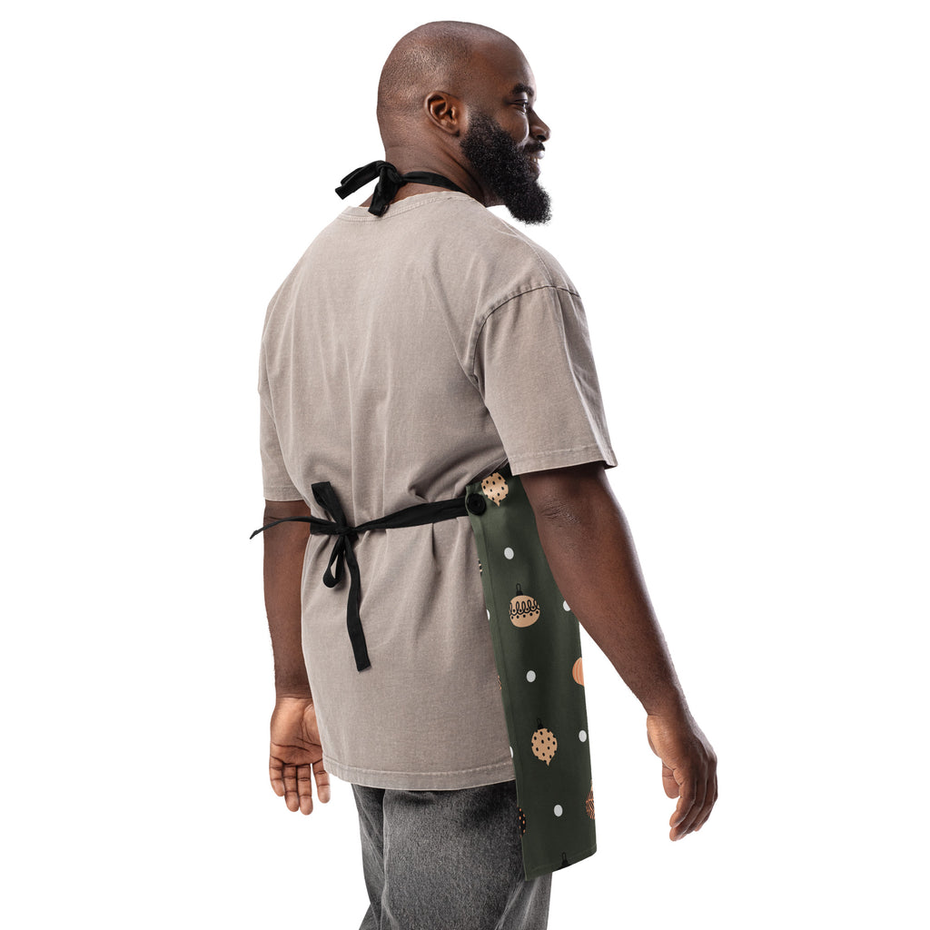 Man wearing of apron, designed with Christmas ornaments with the phrase, " Cooking with Grace".