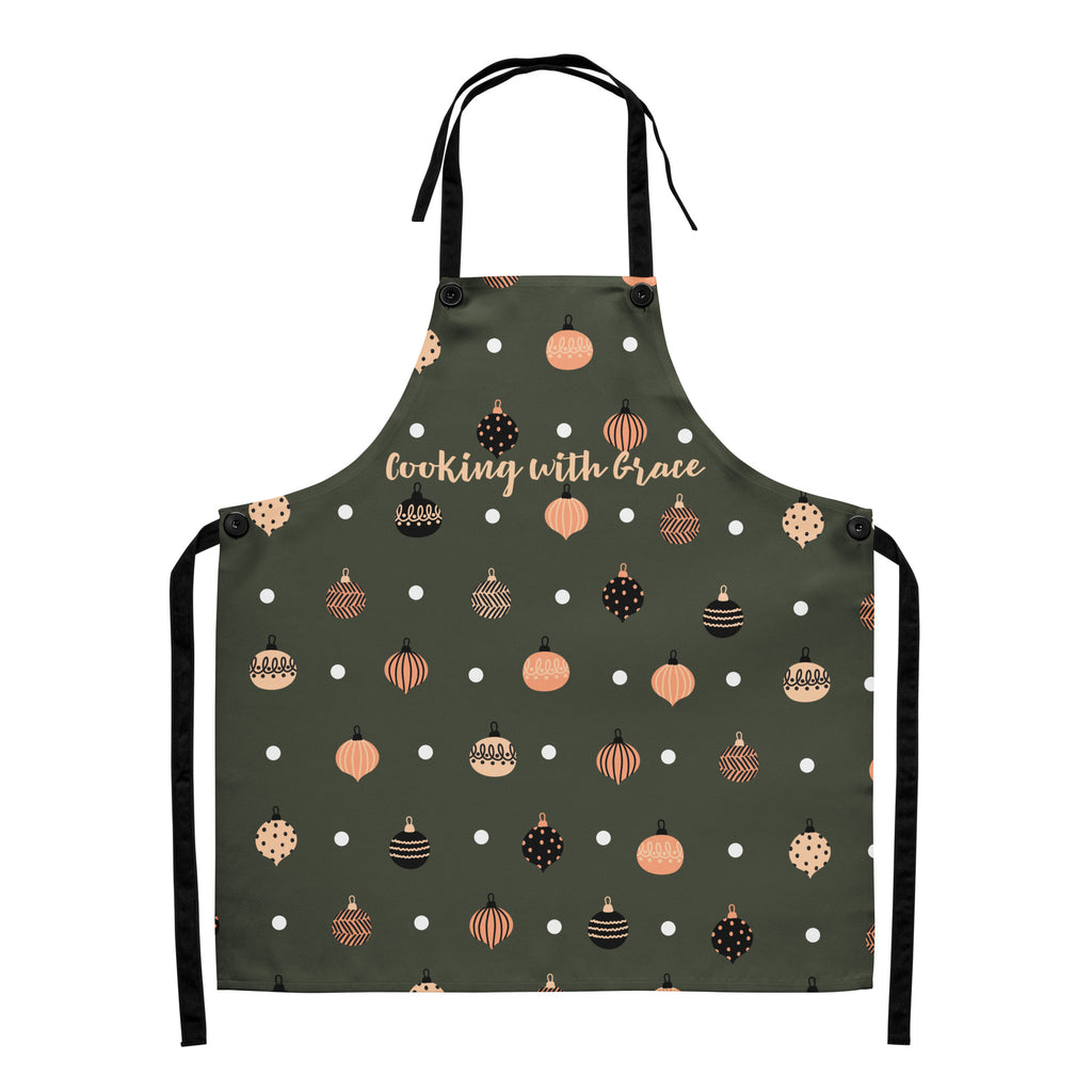 Flat lay view of apron, designed with Christmas ornaments with the phrase, " Cooking with Grace".