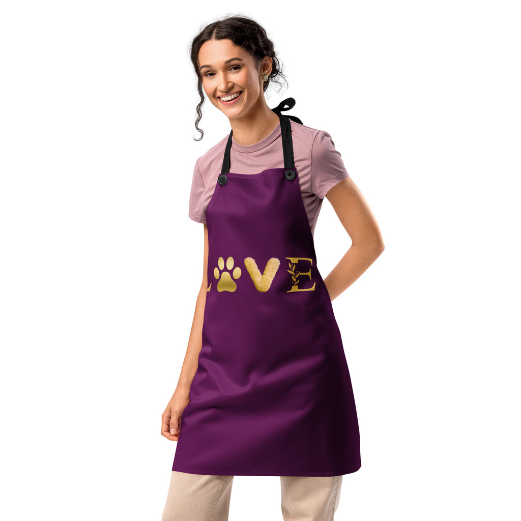 Purple apron featuring the word “LOVE” in gold lettering, with a golden paw print replacing the “O,” symbolizing love for pets and faith in a sleek, elegant design.