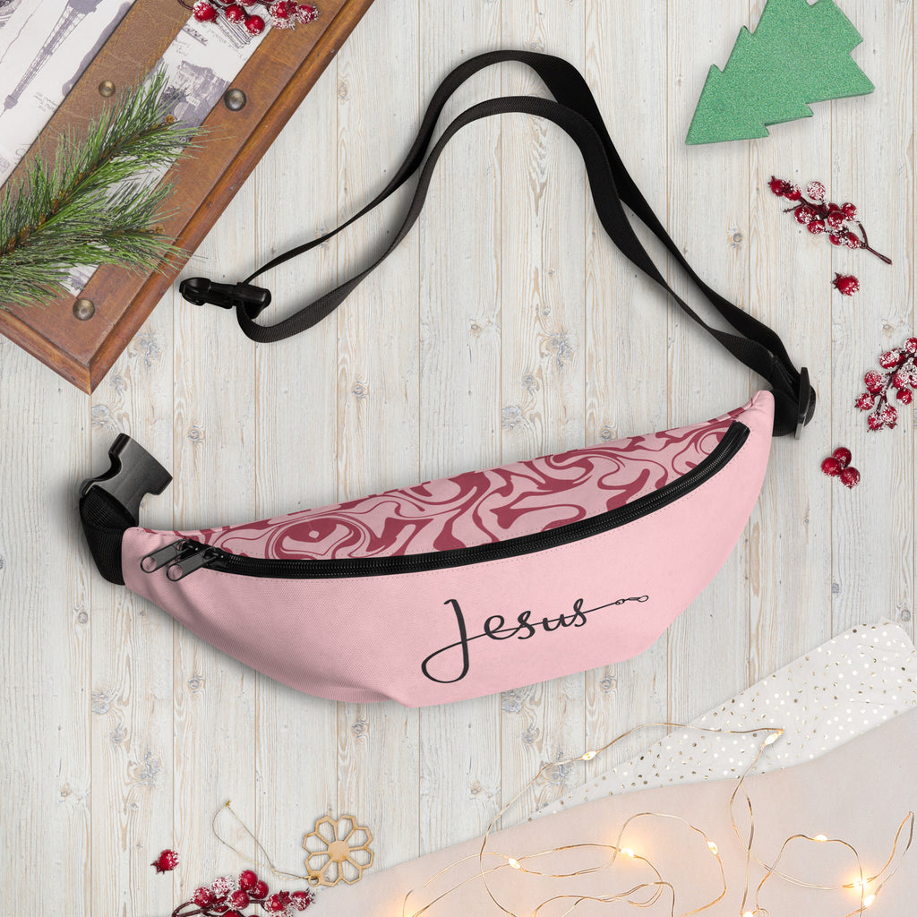 Pink fanny pack featuring the word ‘Jesus’ in black cursive with a leash-style design, faith-inspired accessory