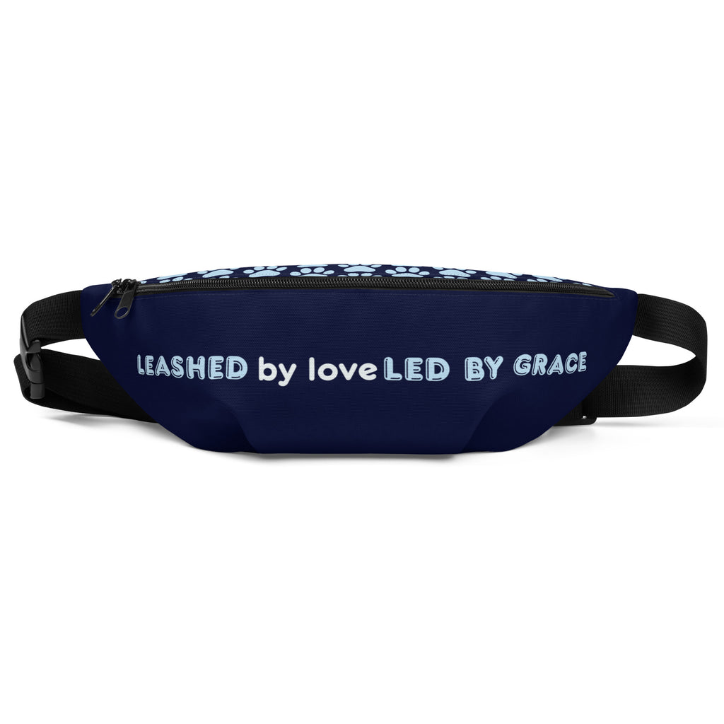 Front view of navy blue fanny pack with the phrase “LEASHED BY LOVE, LED BY GRACE” in light blue letters, decorated with paw prints.