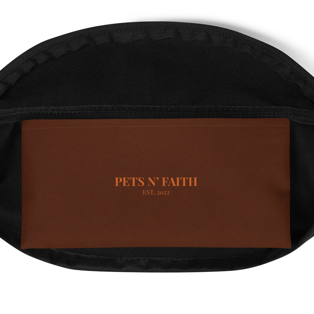 Interior view of brown fanny pack with “PETS N’ FAITH EST. 2022” printed on inside pocket.