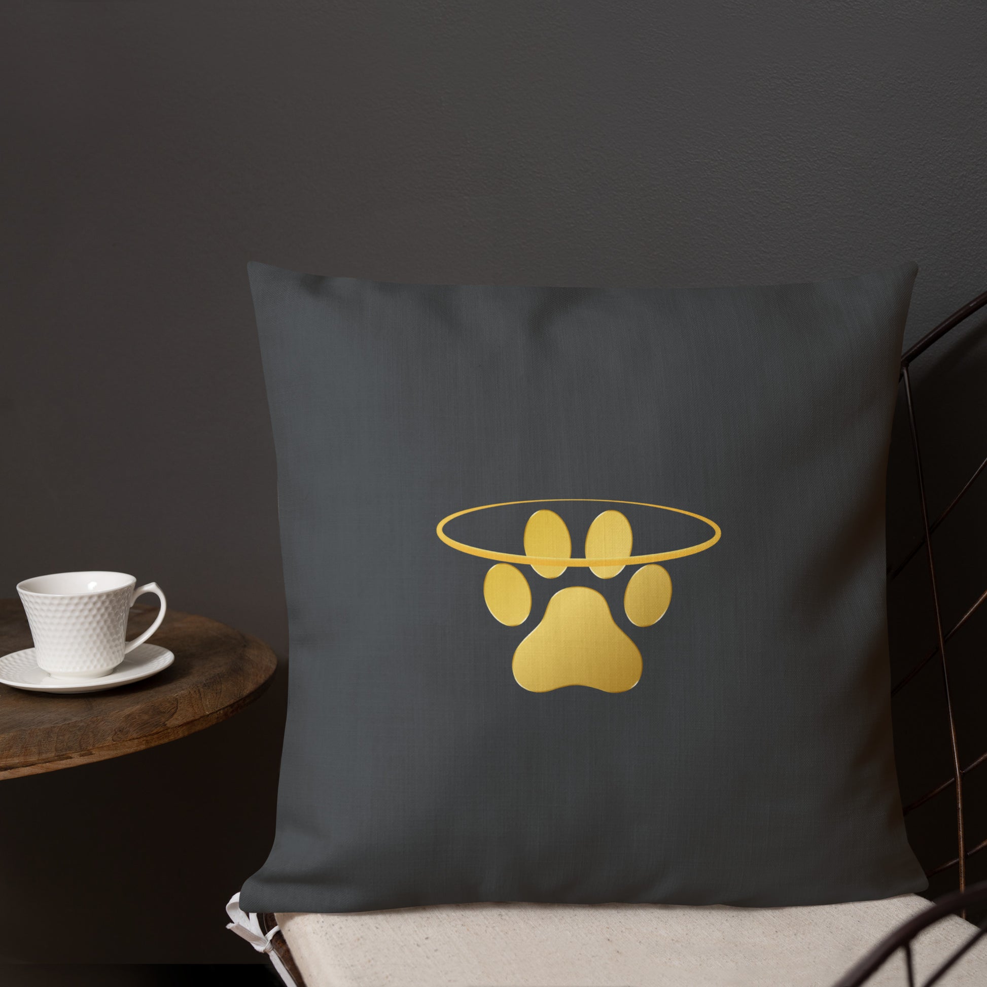 Dark grey pillow with a gold paw print design on a dark background