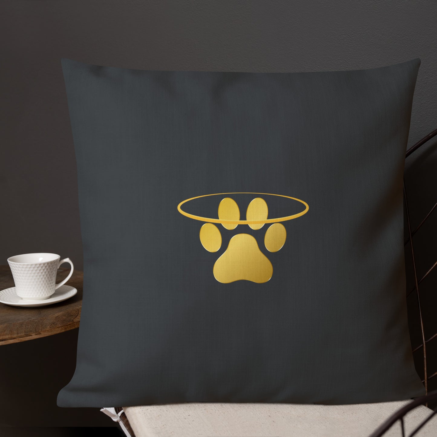 Dark grey  pillow with a gold paw print design on a dark background