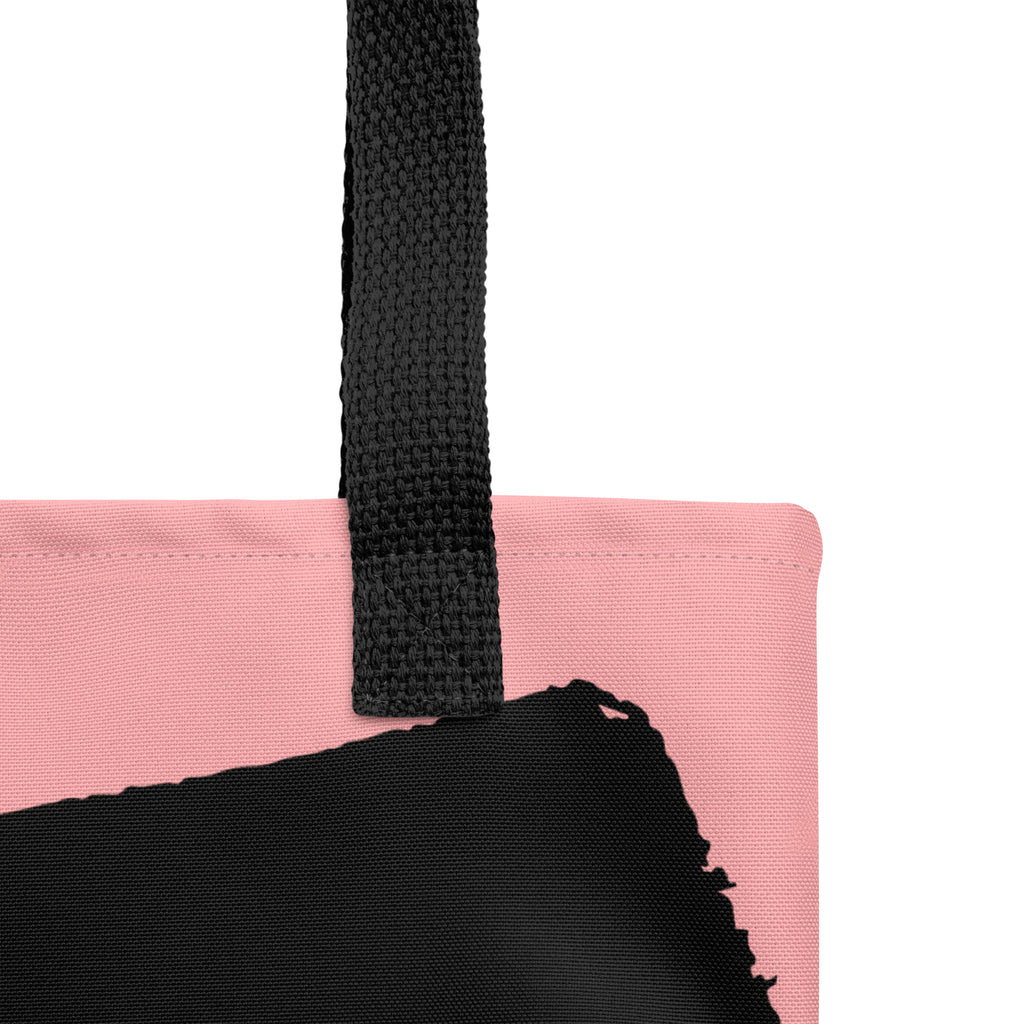 Close-up of Blessed Eco Tote Bag black strap attached to pink organic cotton fabric with visible stitching detail.