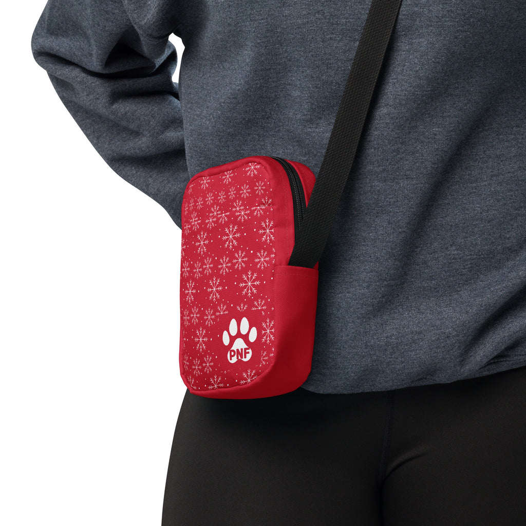 Red crossbody bag featuring a white snowflake pattern, festive holiday design