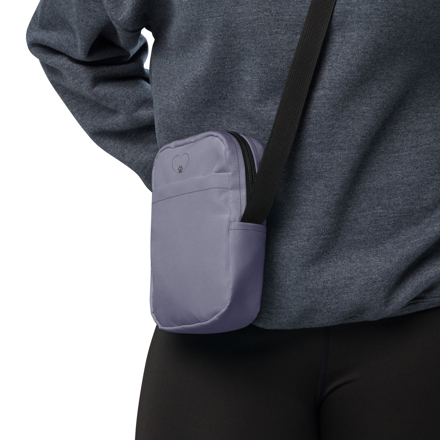 Person wearing a gray sweatshirt with a purple pocket and black strap on a white background