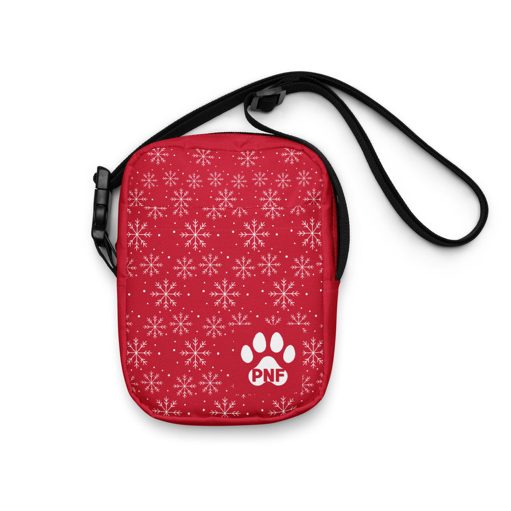 Red crossbody bag featuring a white snowflake pattern, festive holiday design