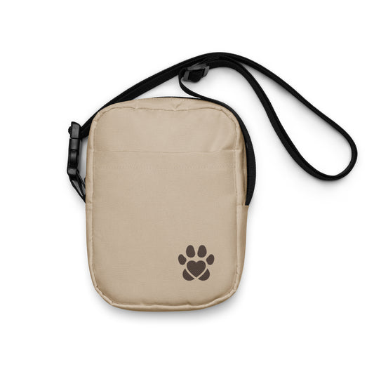 Beige crossbody bag with a brown paw print design on a white background