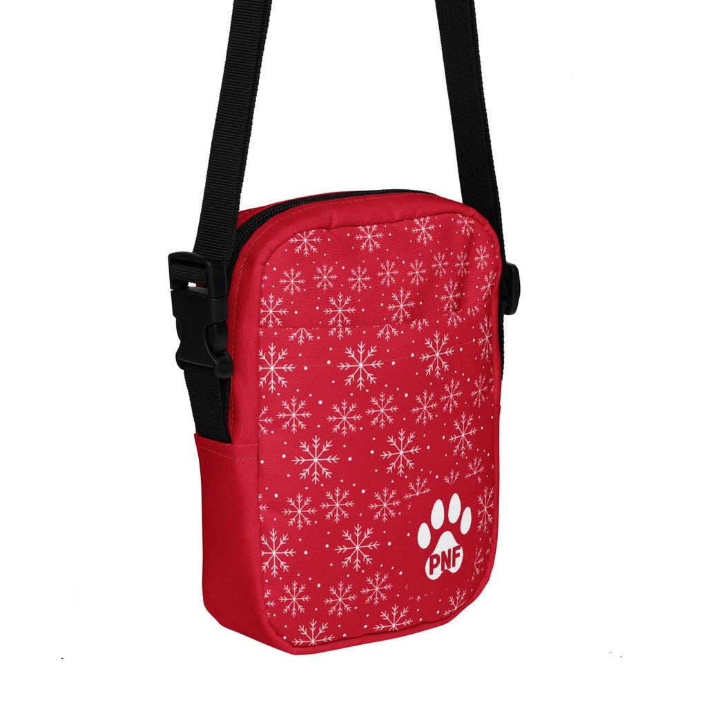 Red crossbody bag featuring a white snowflake pattern, festive holiday design