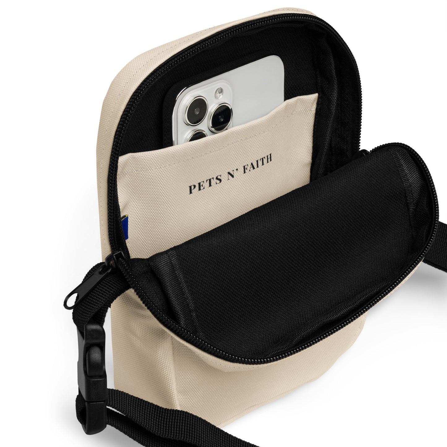 Beige crossbody bag with a phone pocket displaying 'PETS N' FAITH' on a white background