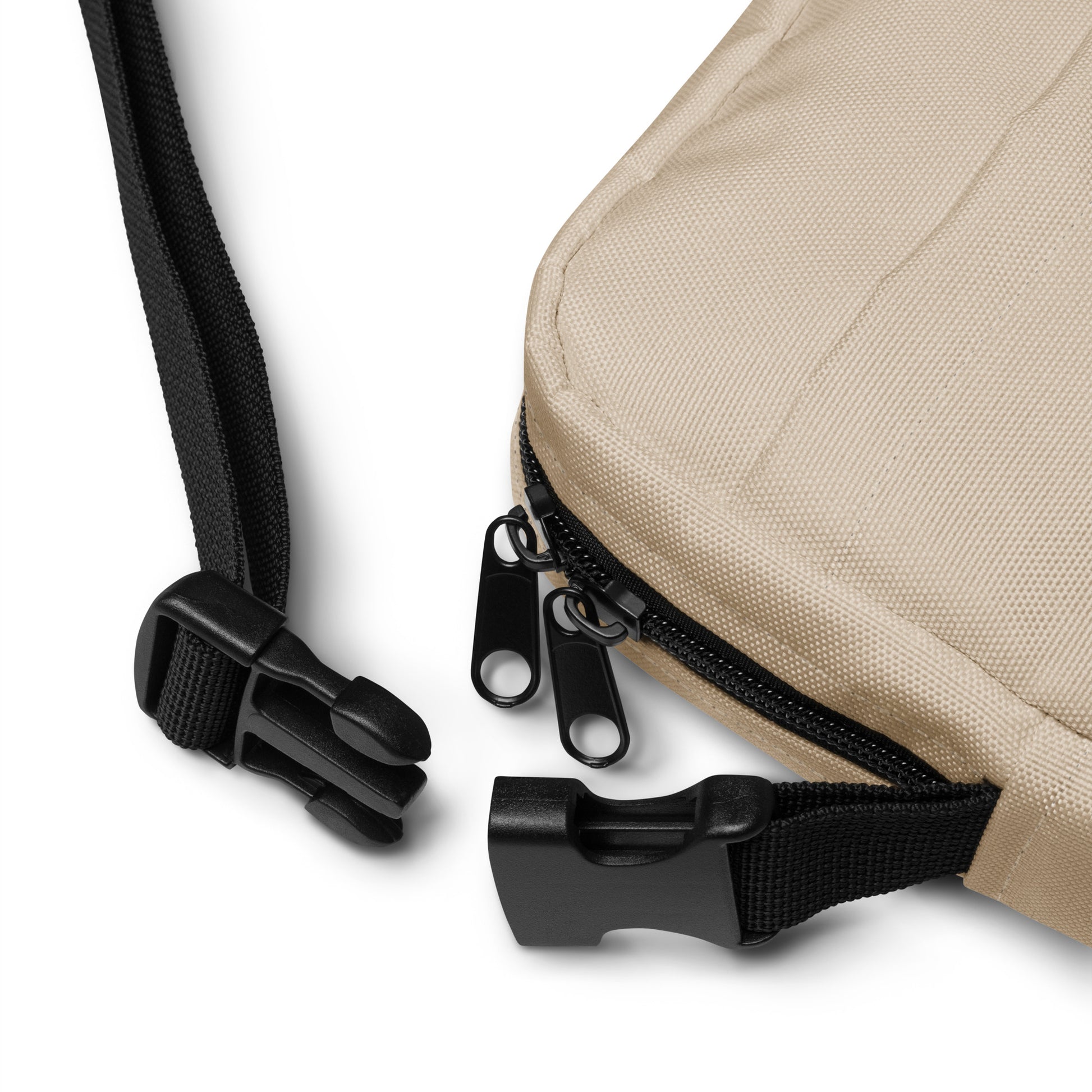 Close-up of beige bag with brown zipper and strap on a white background
