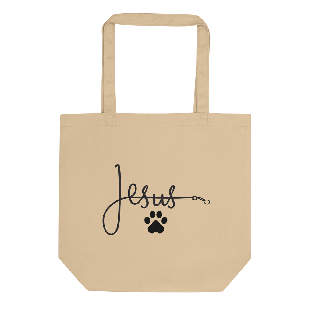 Beige organic cotton tote bag with the word ‘Jesus’ written in cursive connected to a black paw print, symbolizing faith and love for pets – by Pets N’ Faith