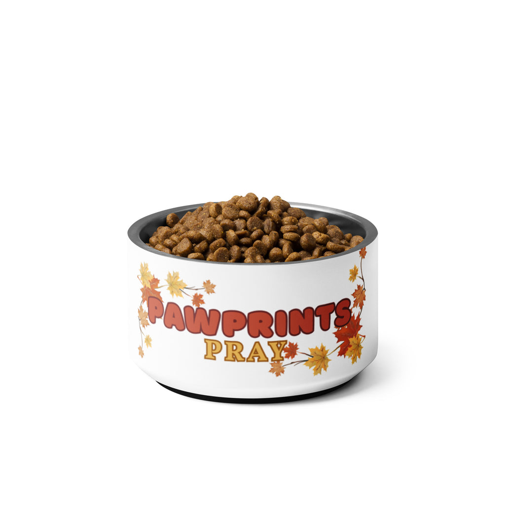 Stainless steel pet bowl with "Pawprints Pray" text and autumn leaf design, empty.