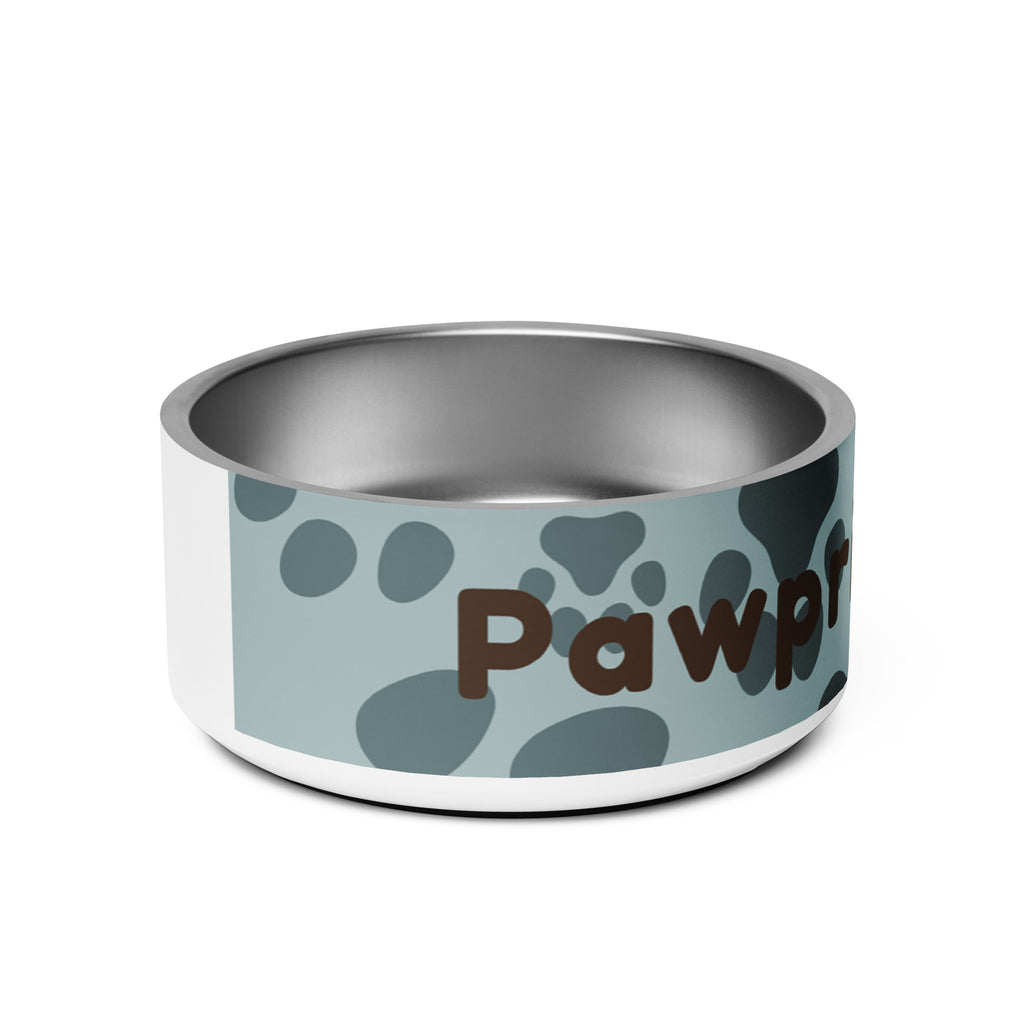 Side view of stainless steel pet bowl with soft blue background and scattered dark paw prints, featuring the text “Pawprints Pray” in brown bold and handwritten font.