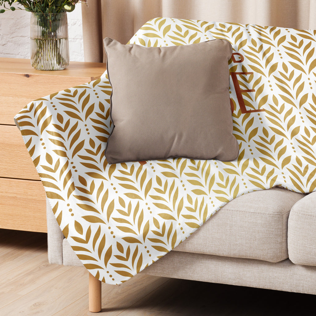 Sherpa blanket featuring a gold leaf pattern and “Paws and Praise” lettering in warm tones, a faith-inspired design that symbolizes gratitude, comfort, and the love between pets and their owners.