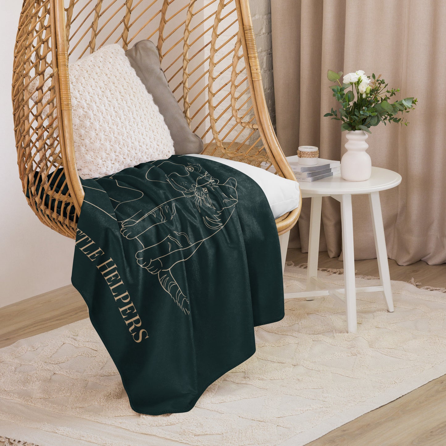 Dark green blanket with text draped over a wicker chair in a cozy room.