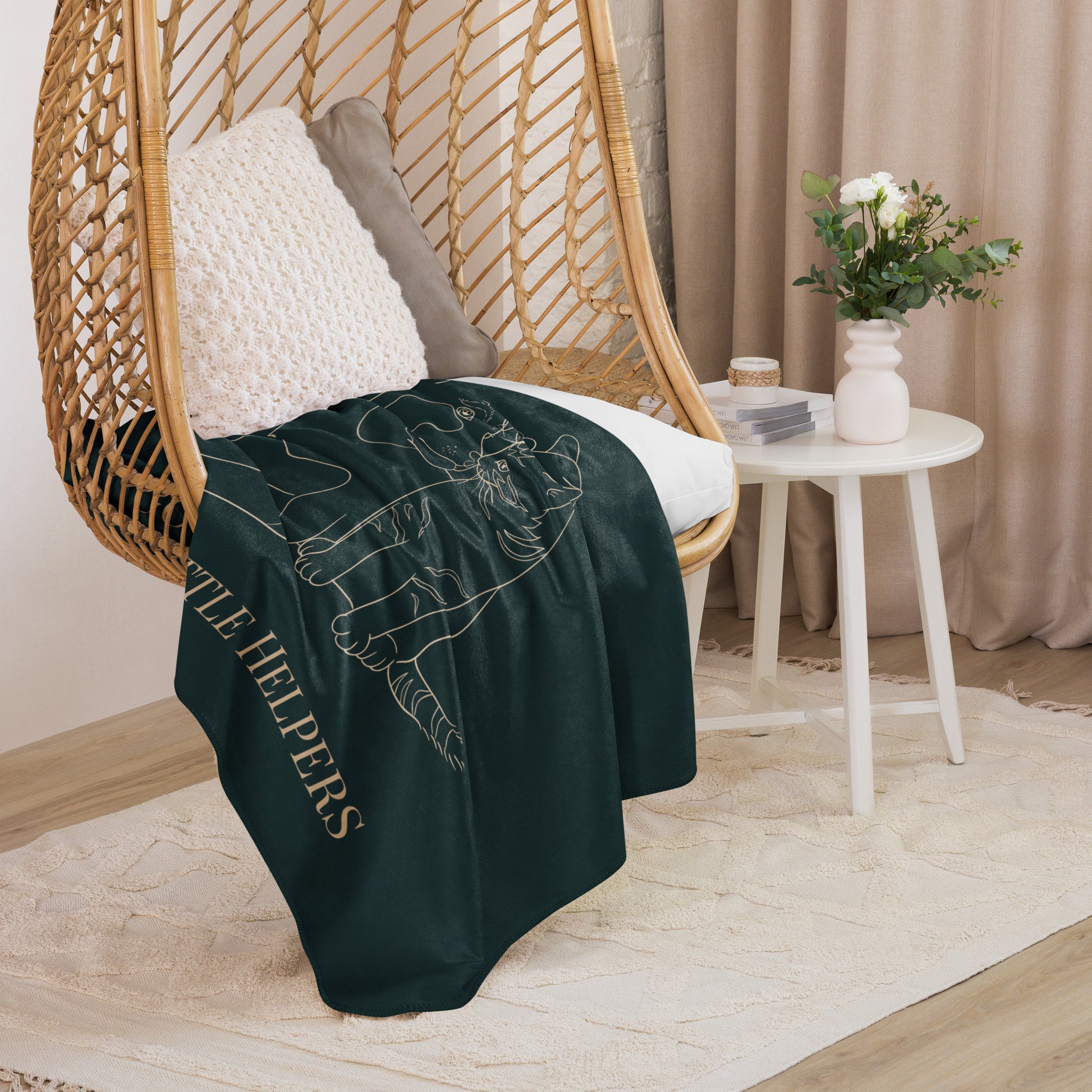 Dark green blanket with text draped over a wicker chair in a cozy room.