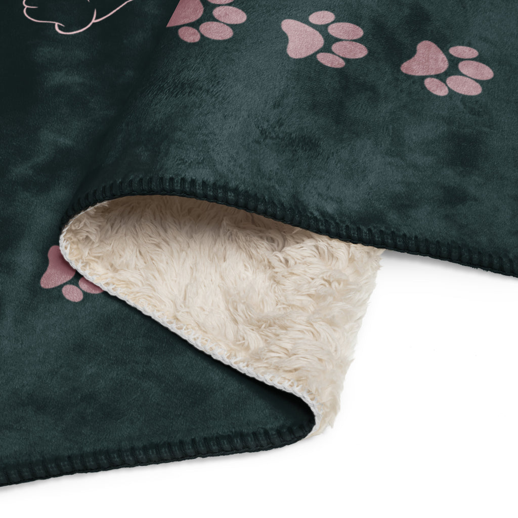 Close up view of forest green sherpa blanket with pink drawings of cats and dogs with the phrase, " God's Little Helpers". 