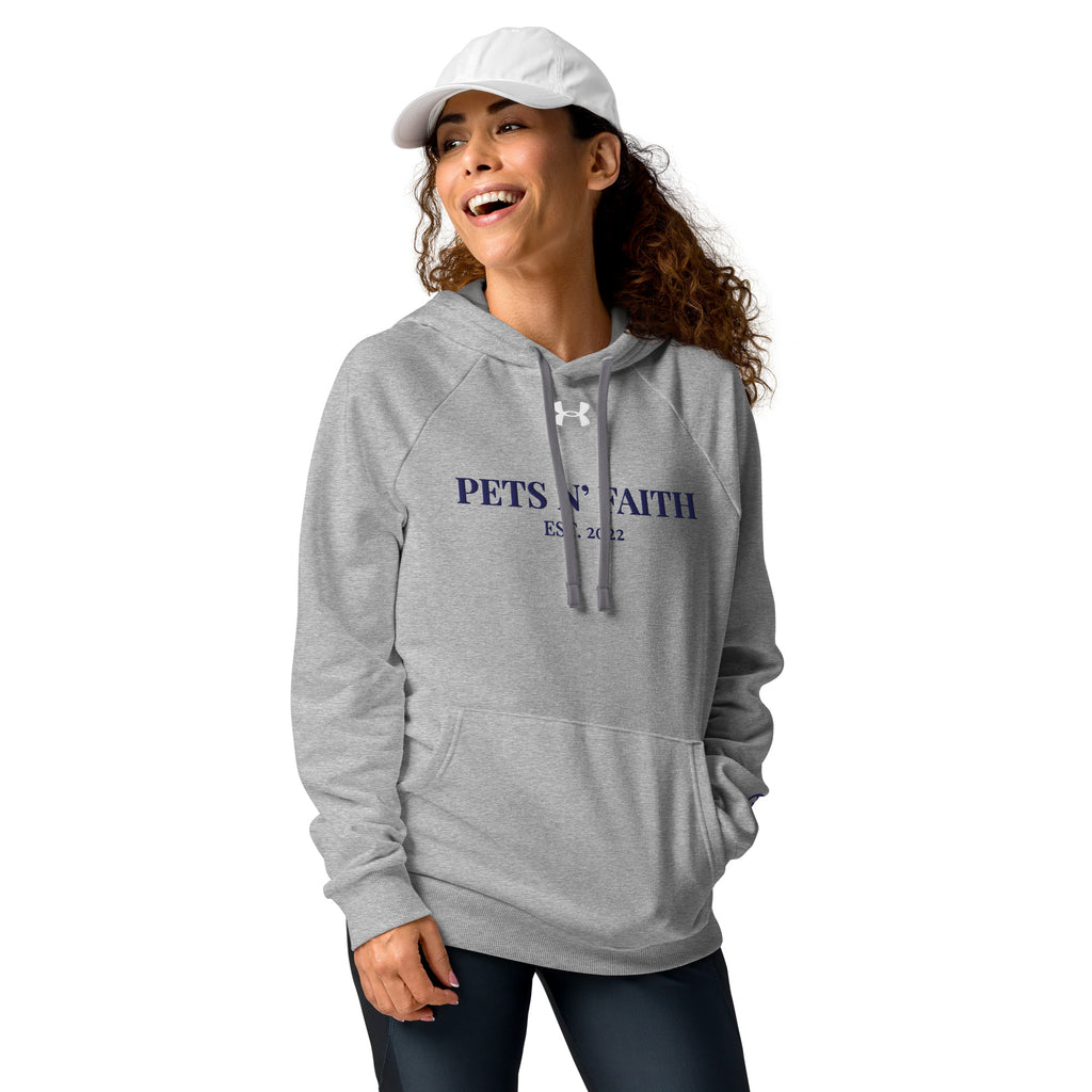 Woman with white hat  wearing light gray Under Armour Pets N’ Faith Hoodie with navy text and kangaroo pocket.