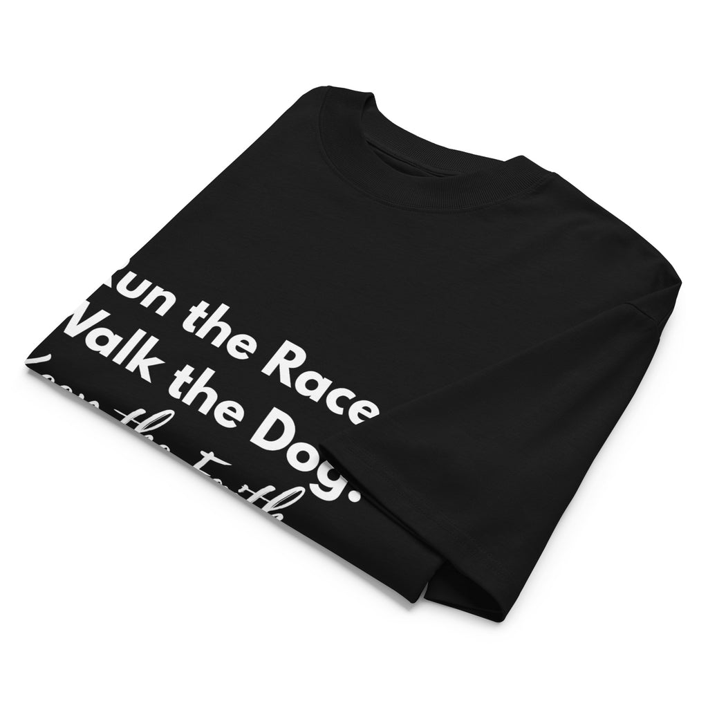 Folded black oversized Pets N Faith t-shirt with faith-inspired slogan partly visible