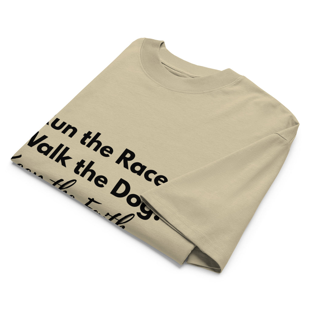 Folded khaki oversized Pets N Faith t-shirt with faith-inspired slogan partly visible